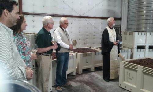 Mike Lewellen, Megan McGrath Gates, Royce Lewellen, Louis Lucas, Fr. John Finley blessing the grapes