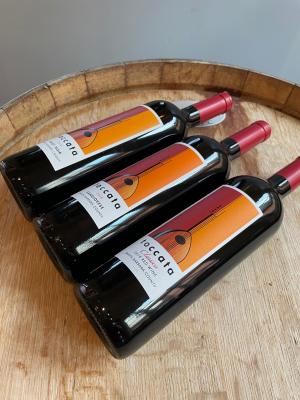 Three bottles of Toccata wine on a wine barrel